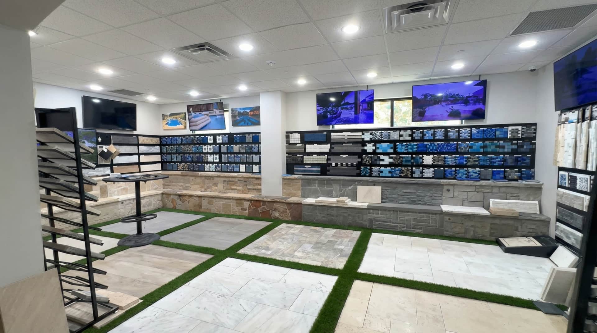 Prestige showroom materials room — tile, coping, stone, and plaster samples on display