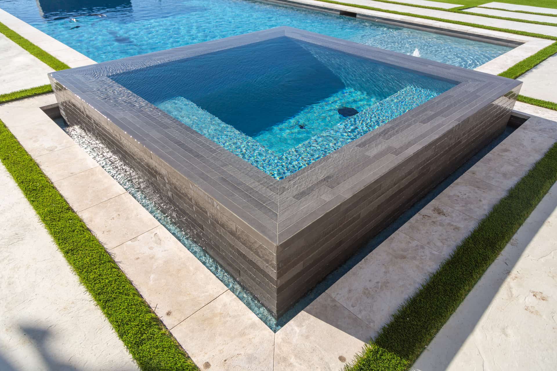 Pool with built-in spa and spillover feature
